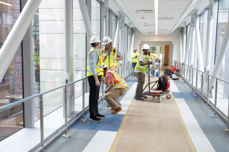 Workers put the final touches on a window-lined bridge connecting the new Jim Ayers Tower to Vanderbilt University Hospital. (photo by Susan Urmy)
