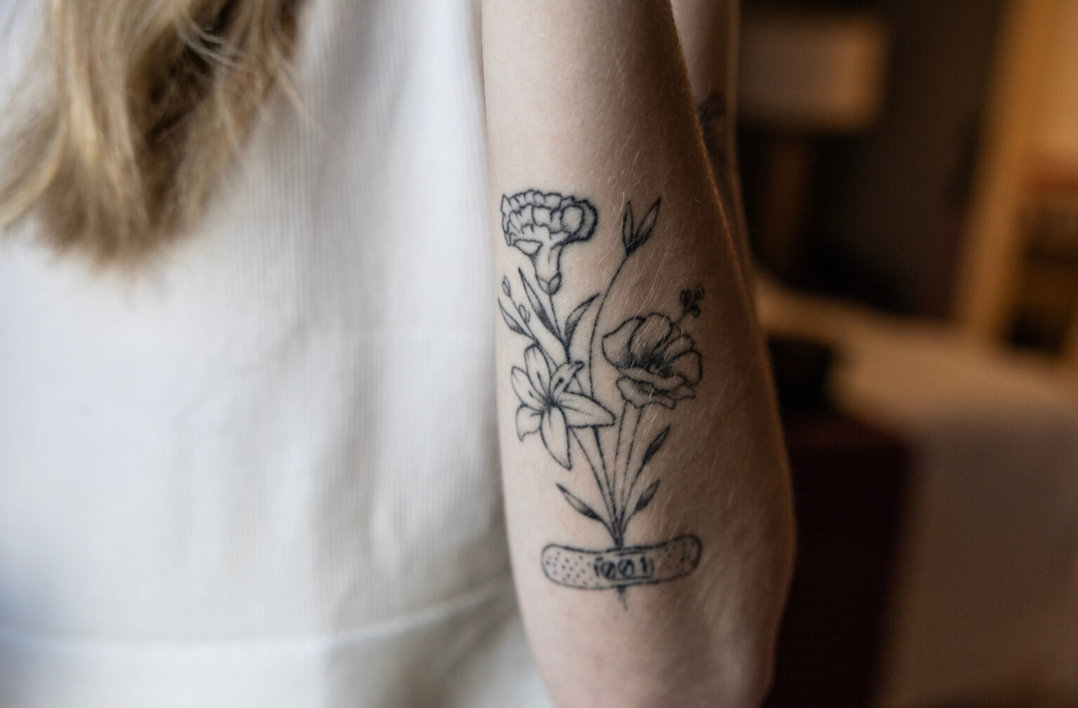Jordyn Bugarin designed her latest tattoo done in Nashville — a bouquet of three flowers representing the month that she started the trial (June), the month that her research coordinator was born (January) and the month that her doctor was born (August). The bouquet is held together by a band-aid that has her patient number on it. (photo by Erin O. Smith)