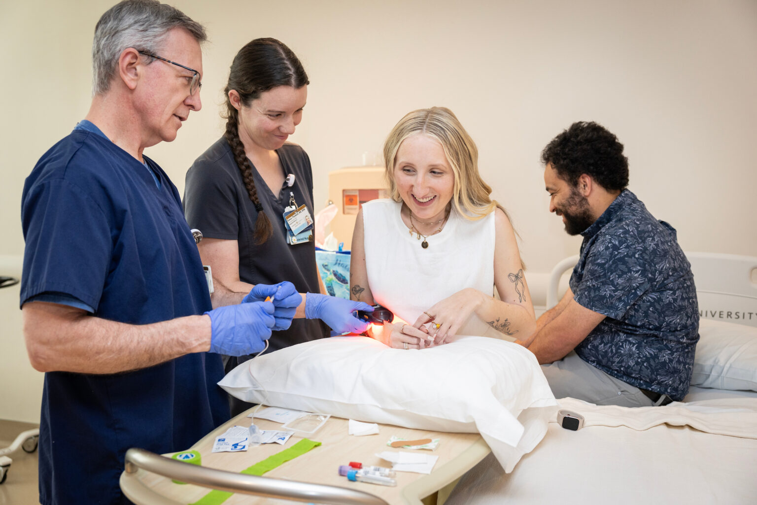 As part of the clinical trial, Jordyn Bugarin regularly traveled to Vanderbilt Health, navigating a complex study while living with a disease that can flare unpredictably and permanently limit movement. Here, Bianca Plunkett, RN, BSN, and Lamar Bowman, RN, BSN, prepare to do a blood draw on Bugarin.