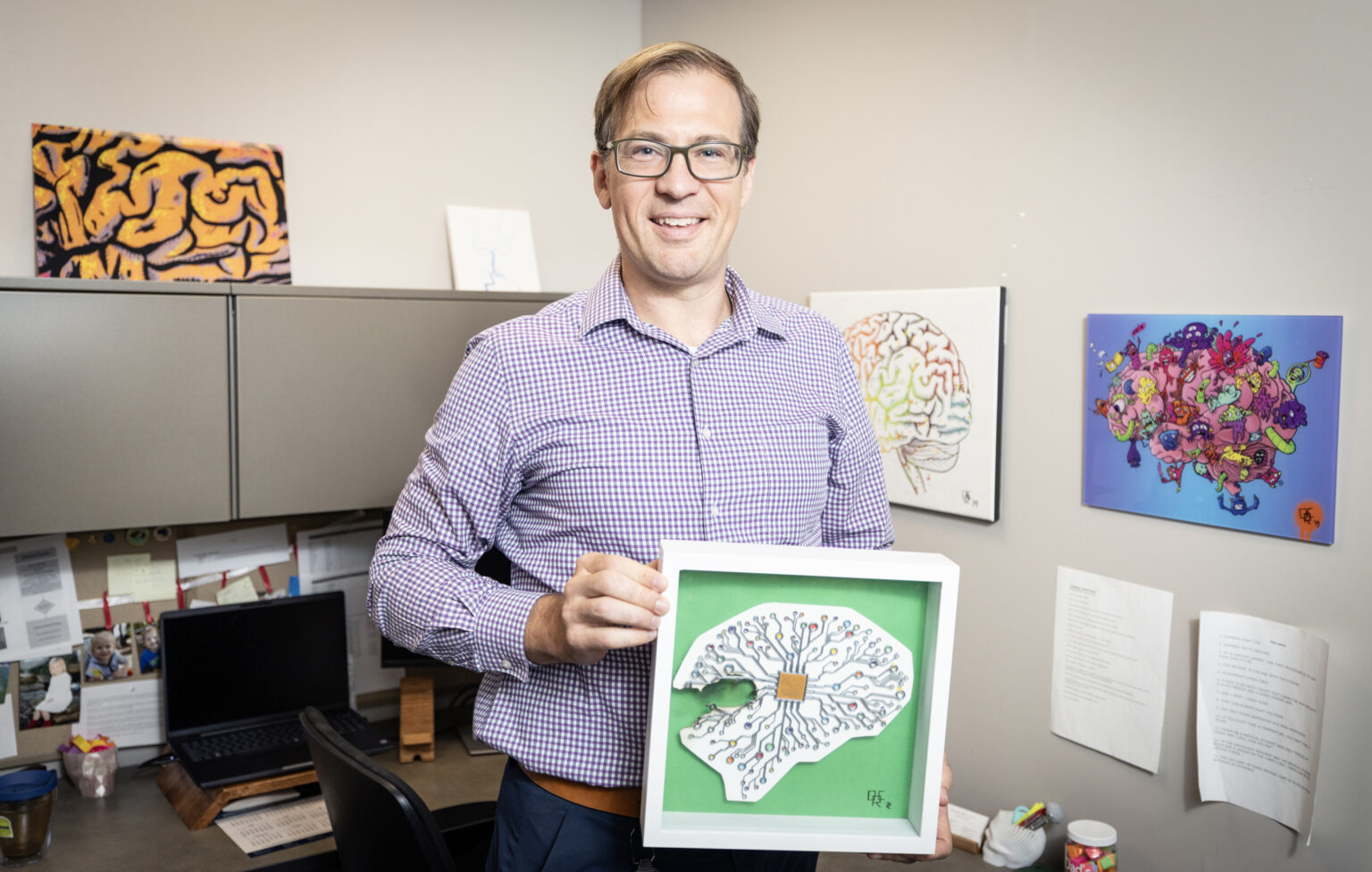 David Curfman, MD, poses for a photo with his artwork in his office at The Vanderbilt Neurology Clinic. (photo by Erin O. Smith)