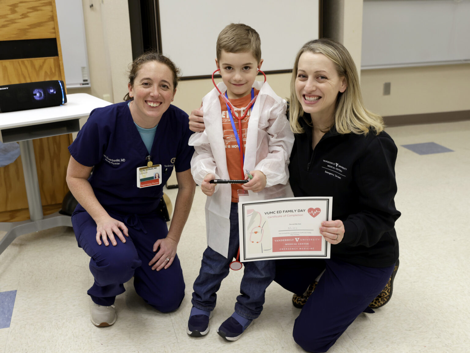 Tara Overbeeke, MD, left, poses for a photo with Jessica Mason, MD, and son, Myles, who received his white coat at VUMC EM Family Day. (photo by Donn Jones)