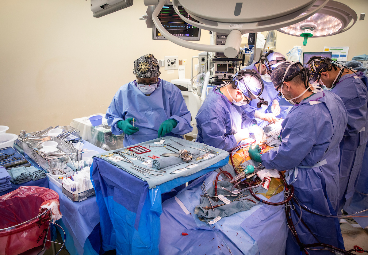Kascey Malone, CST, Brandon Petree, MD, Aaron Williams, MD, Sean Bunch, RN, and Yatrik Patel, MD, work on the transplant patient. (photo by Erin O. Smith)