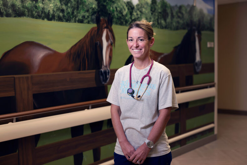 Brittany Ross, RN, stands in front of the mural where her daughter, Jaycey, was once pictured during a hospital stay. Moved by the care her family received, Ross now works as a nurse at Williamson Medical Center. (photo by Donn Jones)
