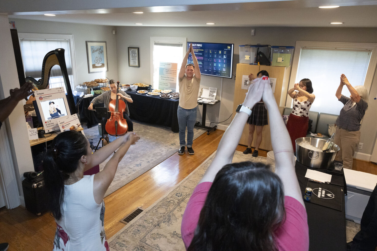 Violinist Tony Parce leads open house visitors in rhythmic yoga with the accompaniment of soft harp music. (photo by Susan Urmy)