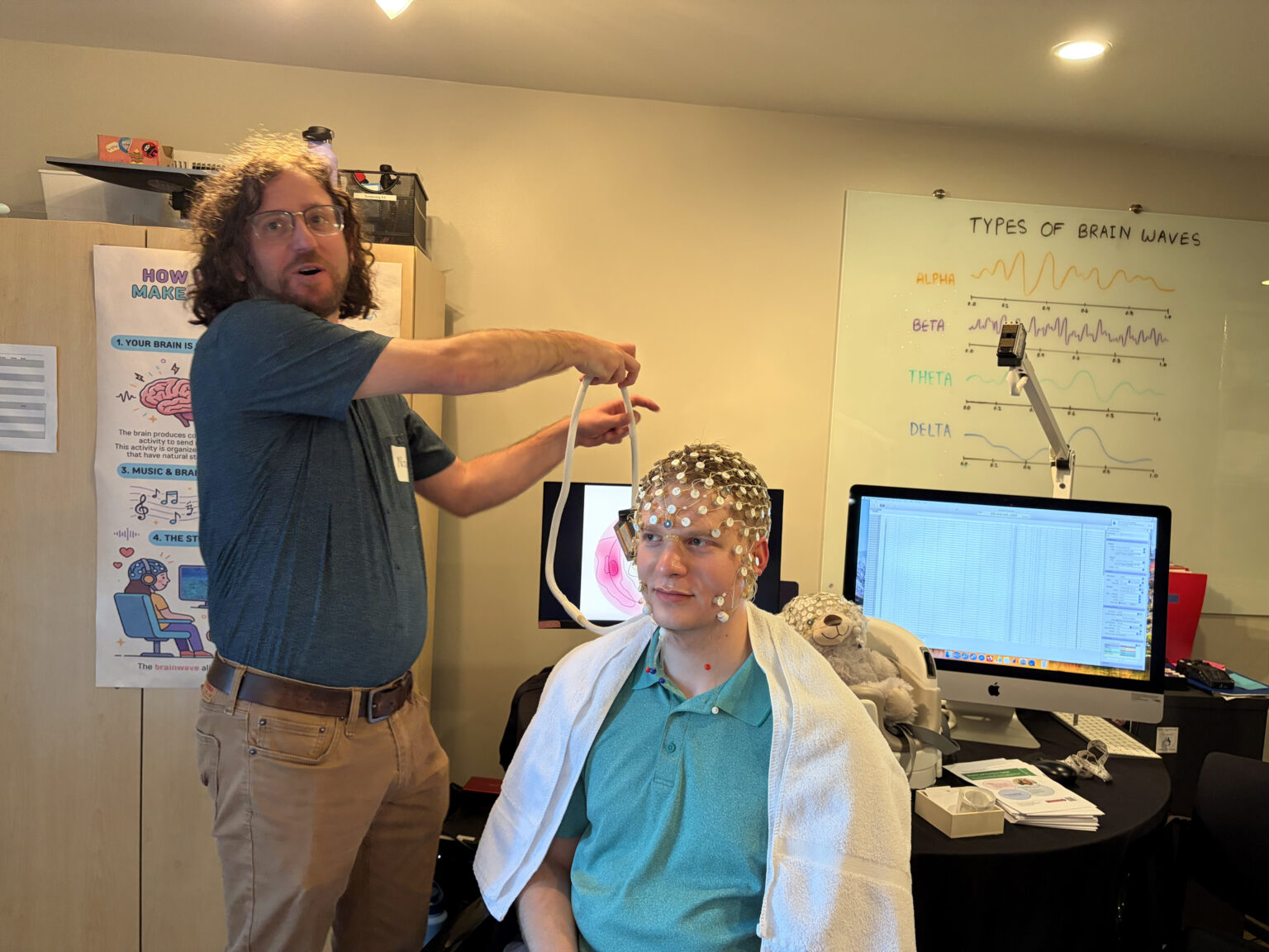 Postdoctoral research fellow Noah Fram gives a demonstration of an electroencephalogram, with Vanderbilt Health News reporter Evan Dorian as a willing participant. (photo by Olivia Kelly)