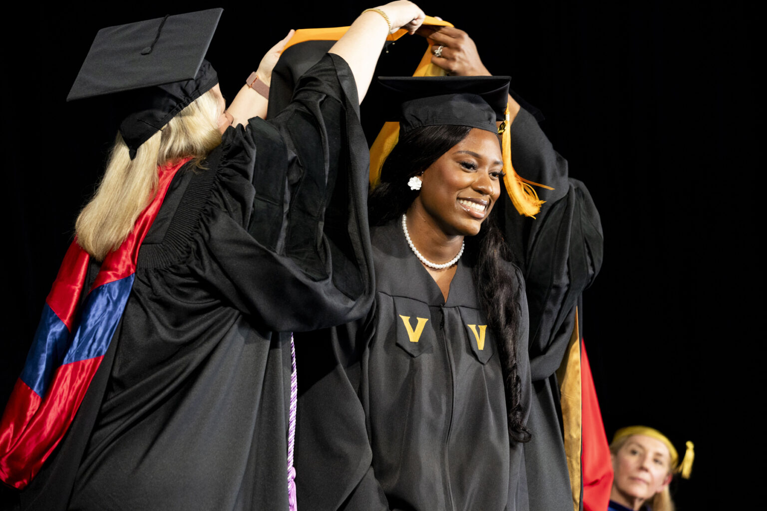 Alexia Skinner-Fisher receives her hood at the School of Nursing ceremony. (photo by Susan Urmy)