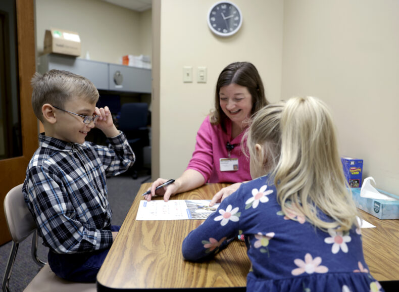 Mark Ogorodnik during a speech pathology appointment with speech language therapist Grace Hastings as his sister, Vita, 5, looks on. (photo by Donn Jones)