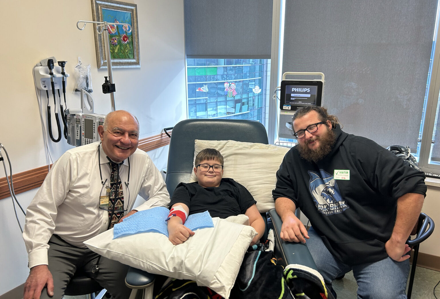 Bill Russell, MD, left, with patient and trial participant Spencer Mannahan and his father, Zach. (photo by Evan Dorian)