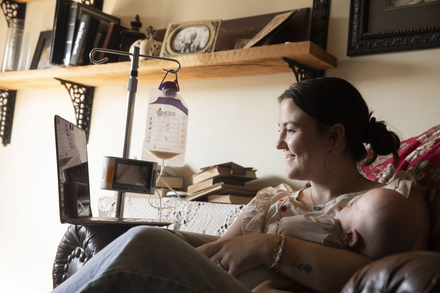 Brittany Saunders, holding her son, Bennett, talks with Julia Peredo, DNP, APRN, during a telehealth visit. (photo by Susan Urmy)