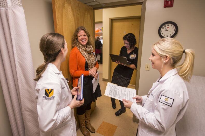 As patients begin arriving for the Shade Tree Early Pregnancy Program, Kameron Brainard, CNM, APN, on left to right in doorway, chats with nurse midwife students. STEPP began to better connect women with obstetric care. (photo by Anne Rayner)