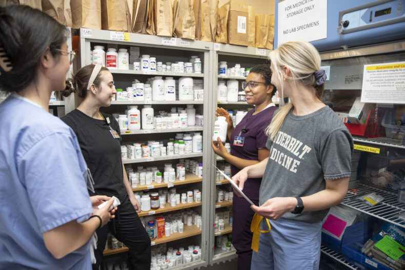 University of Tennessee Health Science Center pharmacy student Imaru Agholor talks with VUSM medical students about medications in the Shade Tree Clinic dispensary. (photo by Susan Urmy)