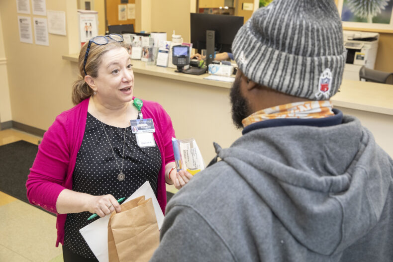 Tracy Hagemann, PharmD, discusses a patient’s new medication with him during a recent Shade Tree Clinic visit. (photo by Susan Urmy)