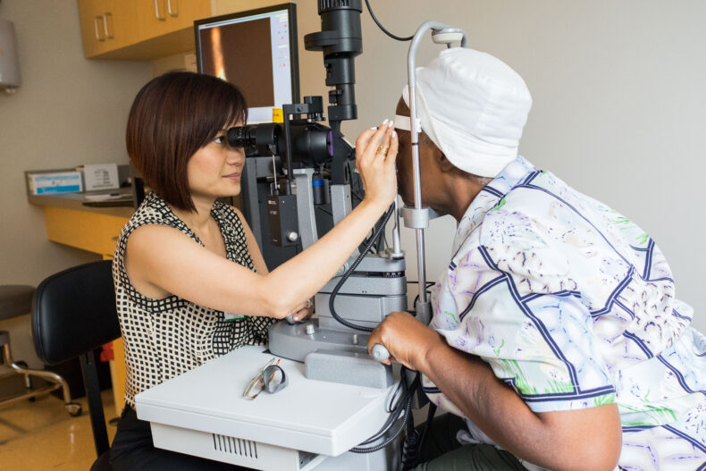 Uyen Tran, MD, professor and division chief of the Cornea and Cataract Surgery Division at the Vanderbilt Eye Institute, performs an exam for a Shade Tree Clinic patient. Ophthalmology services began being offered in 2013. 