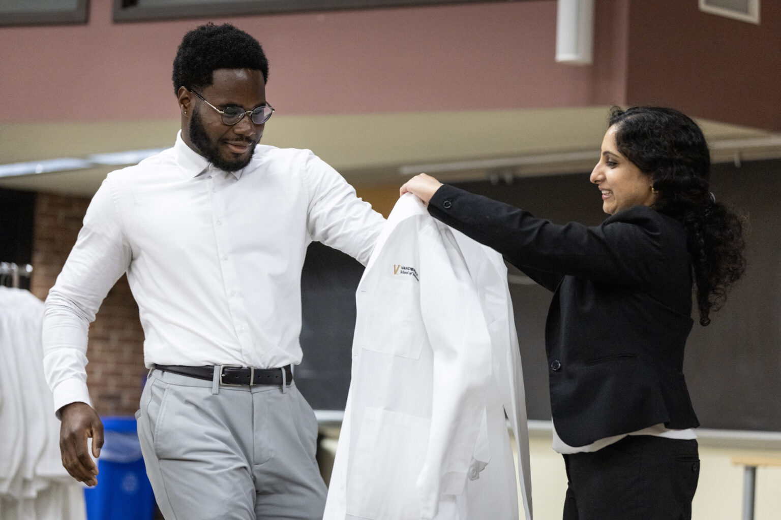 Hugh Barrington Lawrence III, from Beacon, New York, admitted to the Interdisciplinary Graduate Pathway, receives his white coat from IGP Director Madhvi Venkatesh, DPhil, Assistant Professor of Biochemistry. (photo by Erin O. Smith)