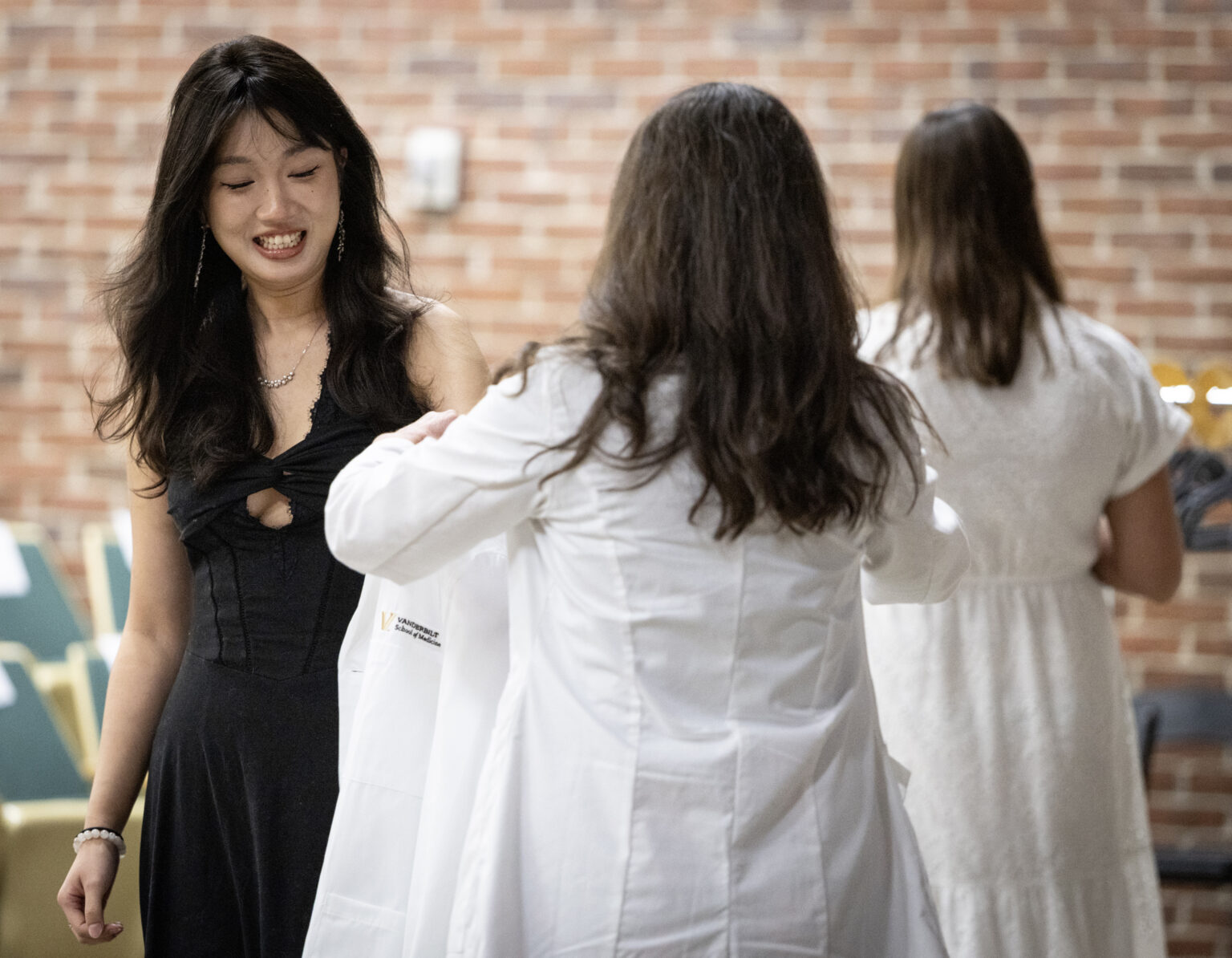 Wanting Shan, a Cancer Biology PhD student, accepts her white coat from Rachelle Johnson, PhD. (photo by Erin O. Smith)