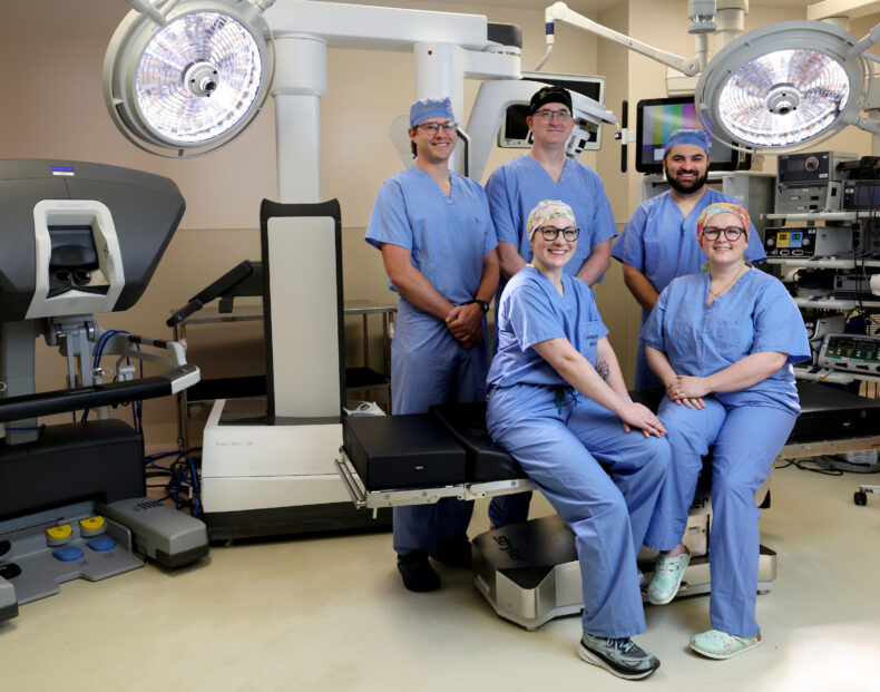 Members of the Vanderbilt Health Colon and Rectal Surgery team in front of the single-port (SP) robotic system they use for colorectal surgeries. The team includes, front row, left to right, Katie Martin, PA-C; and Shannon McChesney, MD. Back row, left to right, Phillip Williams, MD, MSc; M. Benjamin (Ben) Hopkins, MD; and Aimal Khan, MD. (photo by Donn Jones)