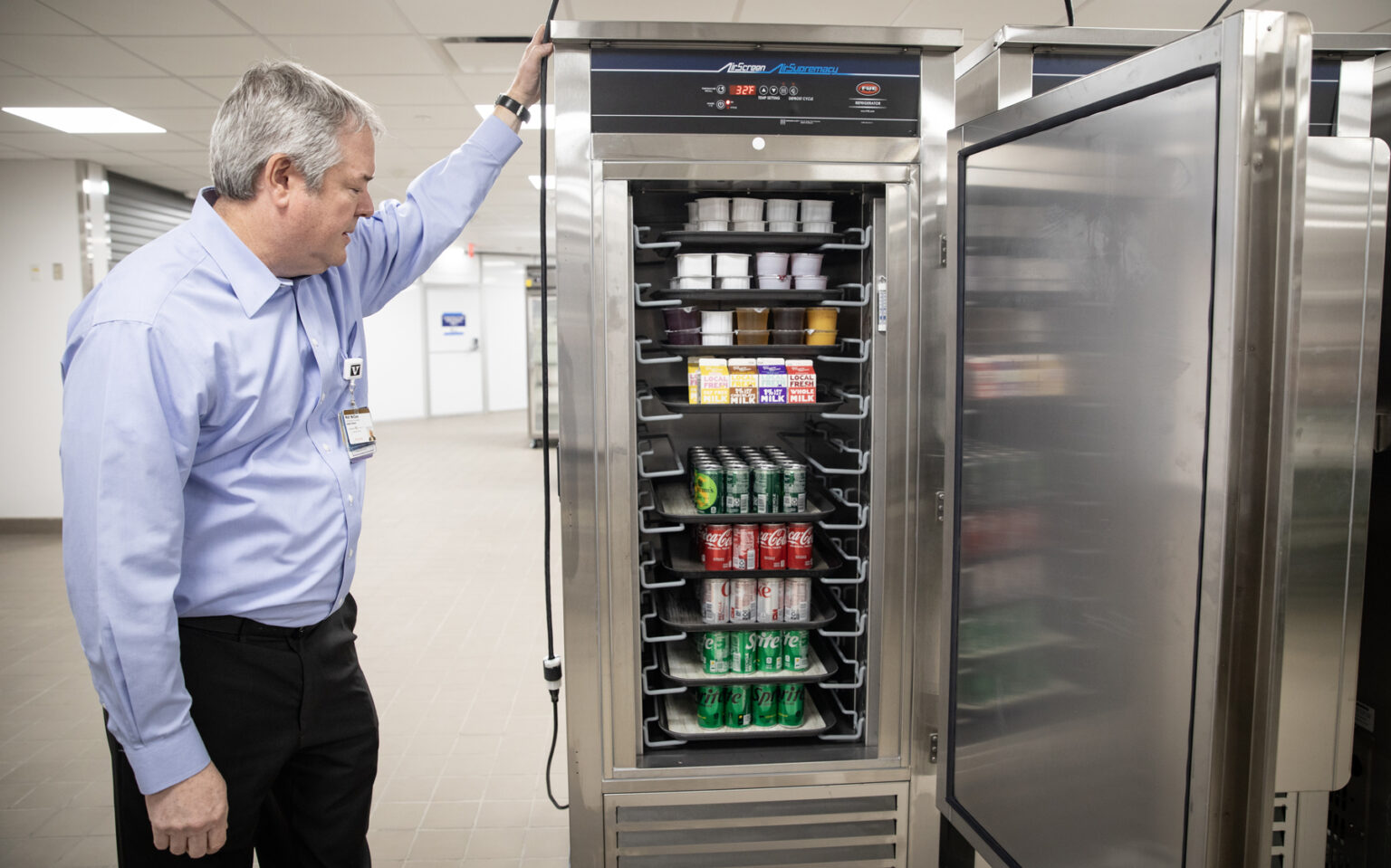 Walt McClure, MBA, director of Food and Nutrition Services, shows off newly stocked treats in the renovated Vanderbilt University Hospital kitchen. (photo by Erin O. Smith)