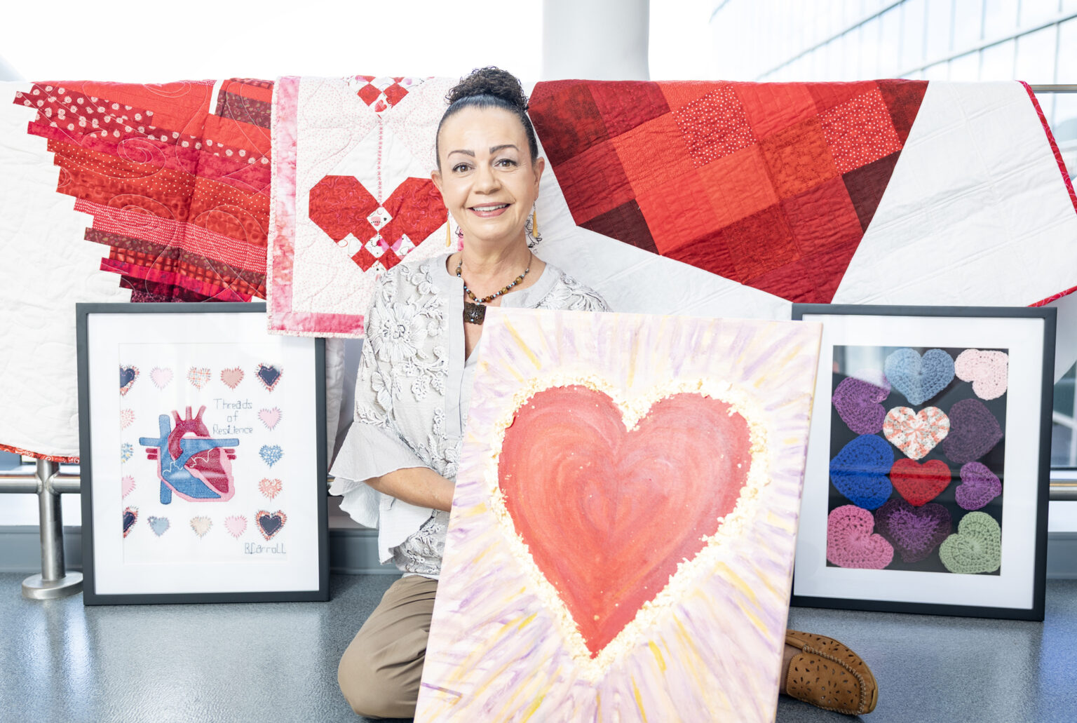 Lauren Michelle Wells Fierro, LCSW, with several of the works created by patients with heart conditions. (photo by Erin O. Smith)
