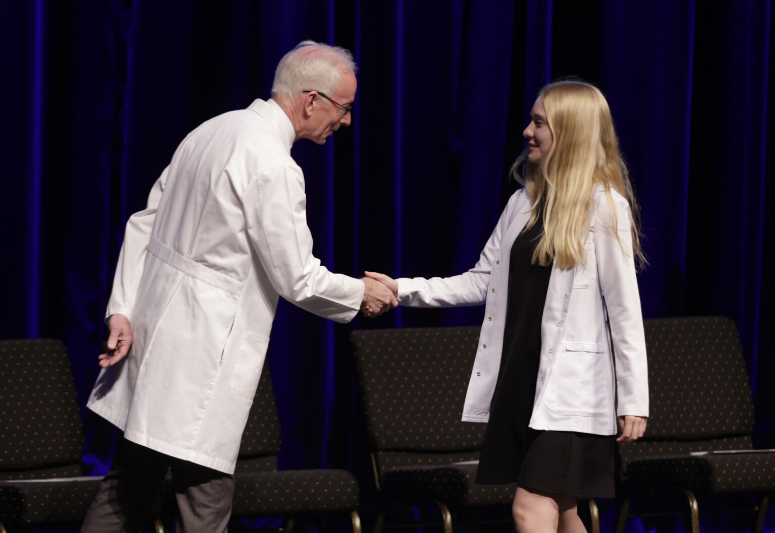 Lily Bensen of St. Paul, Minnesota, is congratulated by Donald Bradley, MD, during the White Coat Ceremony. (photo by Donn Jones)