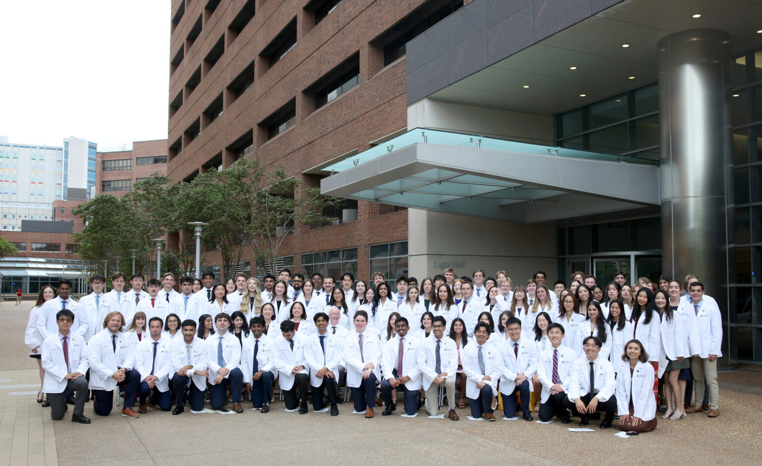 Donald Brady, MD, joins the members of the Class of 2030 in their first official group photo wearing white coats.
