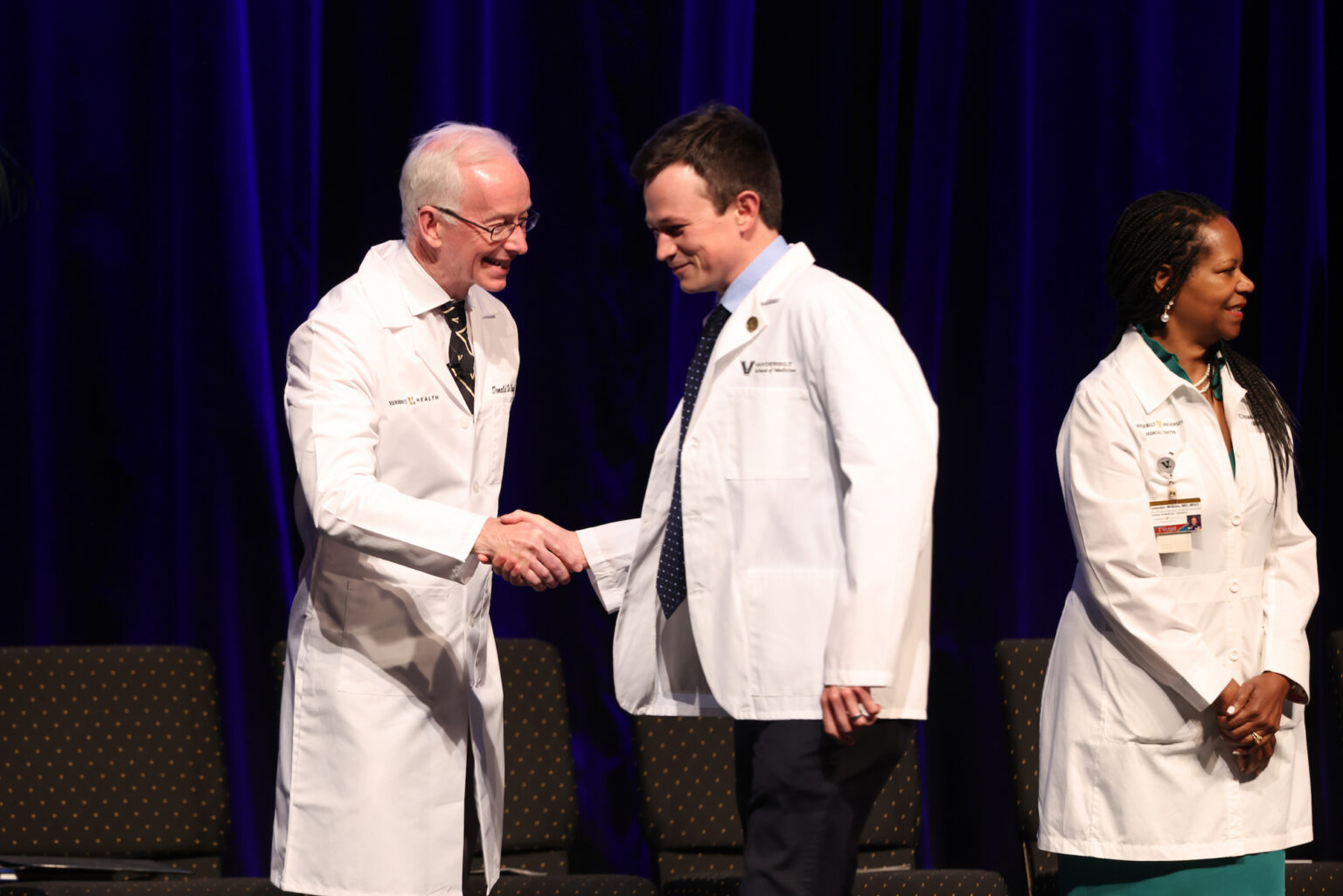Donald Brady, MD, congratulates Alexander Max Raskin, a graduate of the University of Wisconsin-Madison, while Consuelo Wilkins, MD, MSCI, awaits the next student.