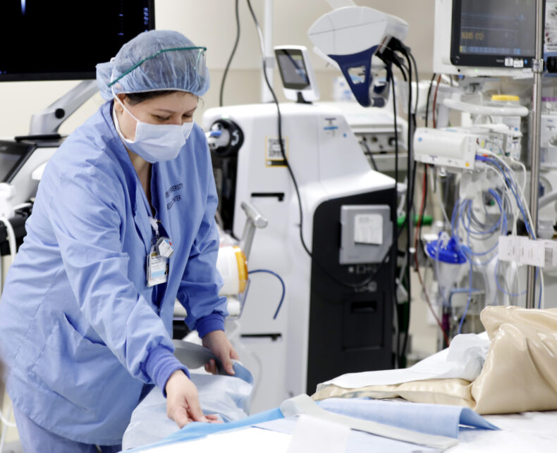 Anahi Choe, RN, prepares the operating table for Aaron Davis' histotripsy procedure. (photo by Donn Jones)