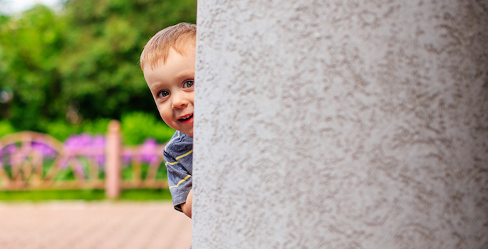 child hiding behind a corner